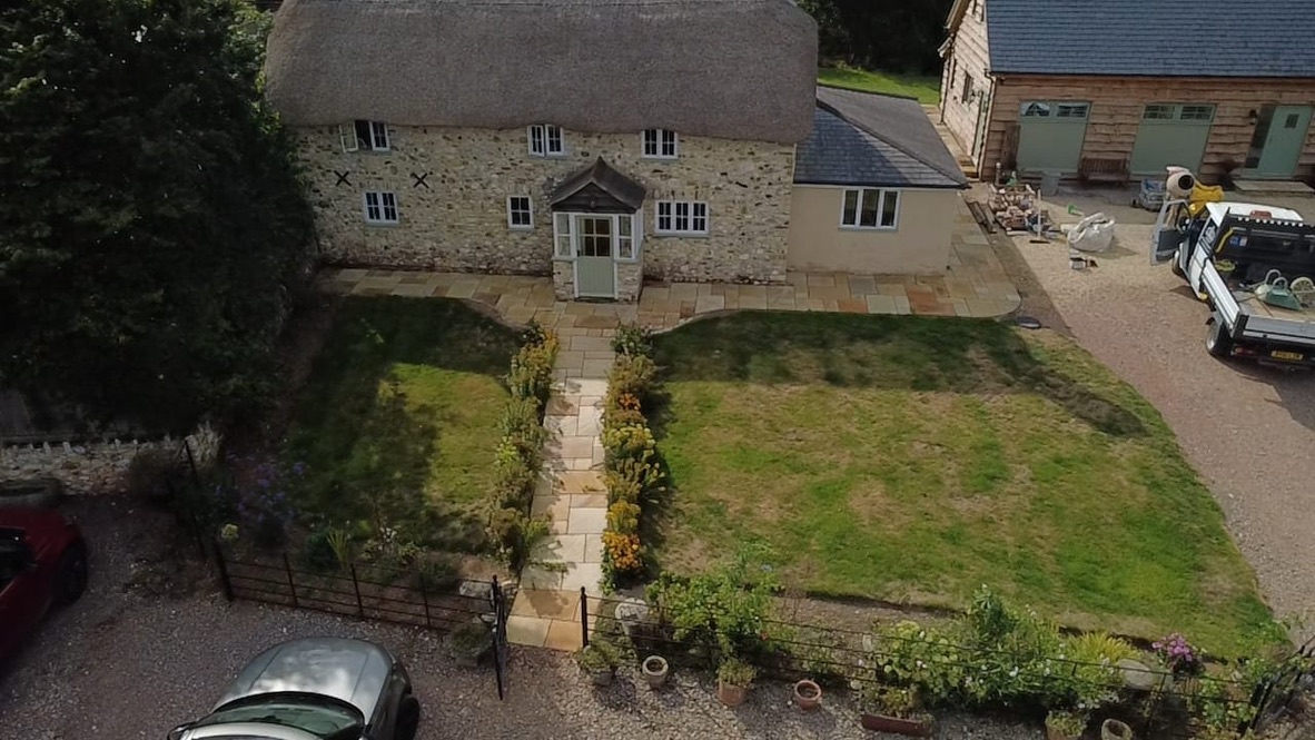 Aerial view of the front of the thatched cottage with the new path and planted borders