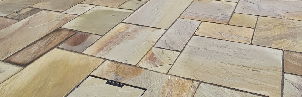 Close view of Mint Indian sandstone slabs laid in a random pattern, showing their varied warm tones