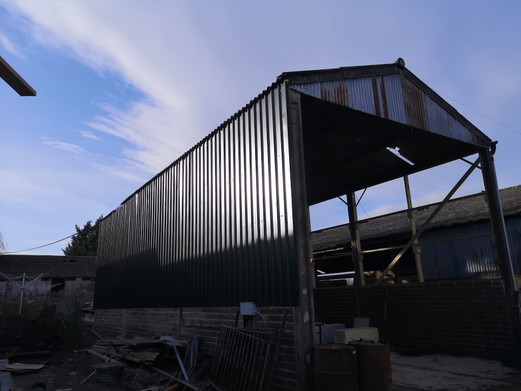 The re-clad barn from the side, showing the full length of the new green steel sheeting