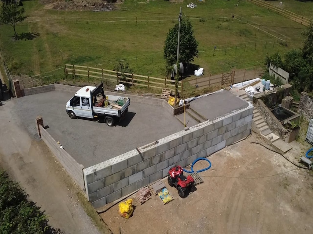 Finished gravel hardstanding and parking area with a concrete block retaining wall