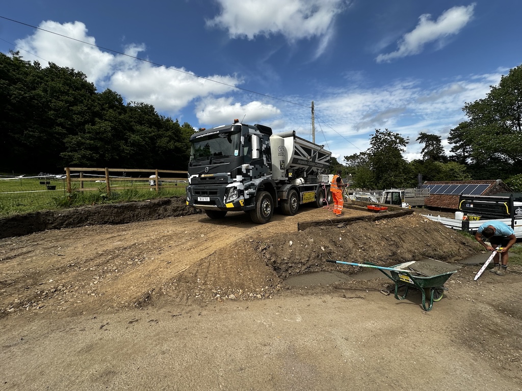 A concrete mixer lorry delivering a pour on a prepared groundworks site