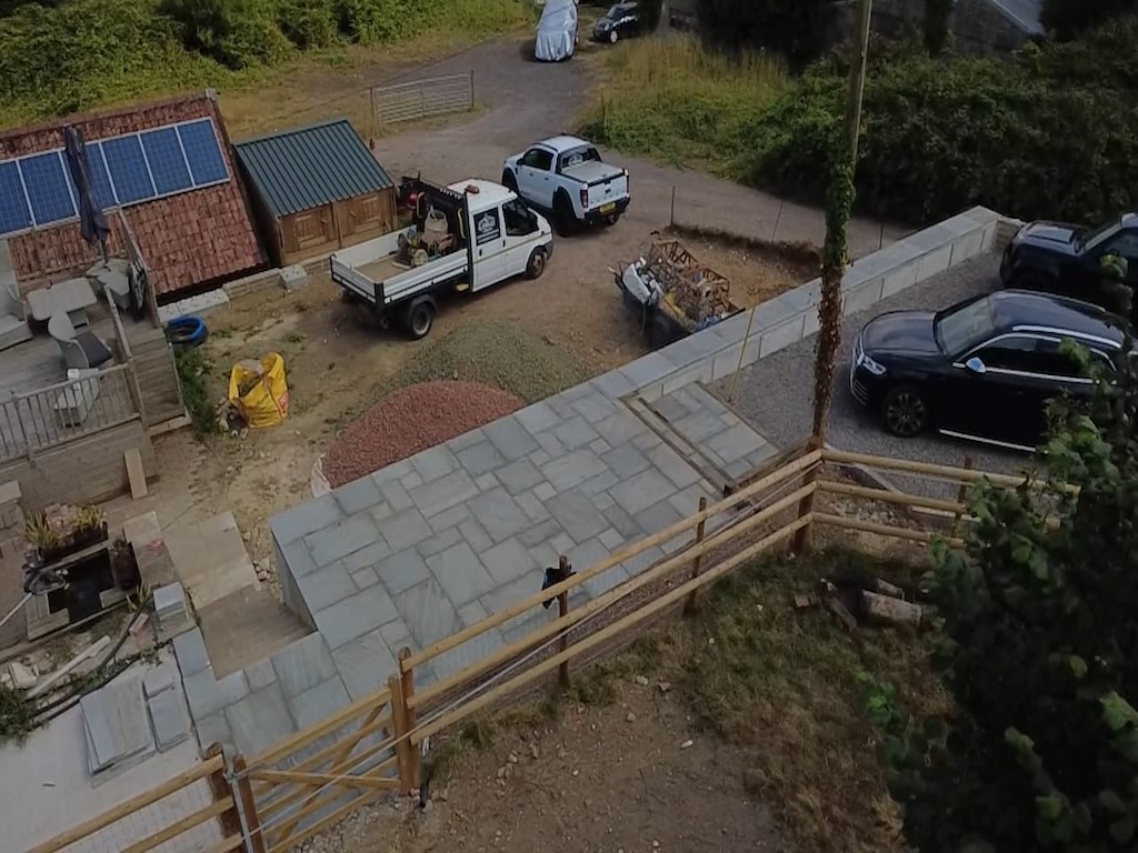 Aerial view of the new patio, parking area and retaining wall beside the property