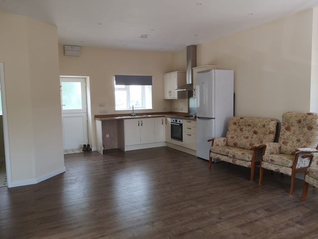 The finished open-plan kitchen and living space with new flooring