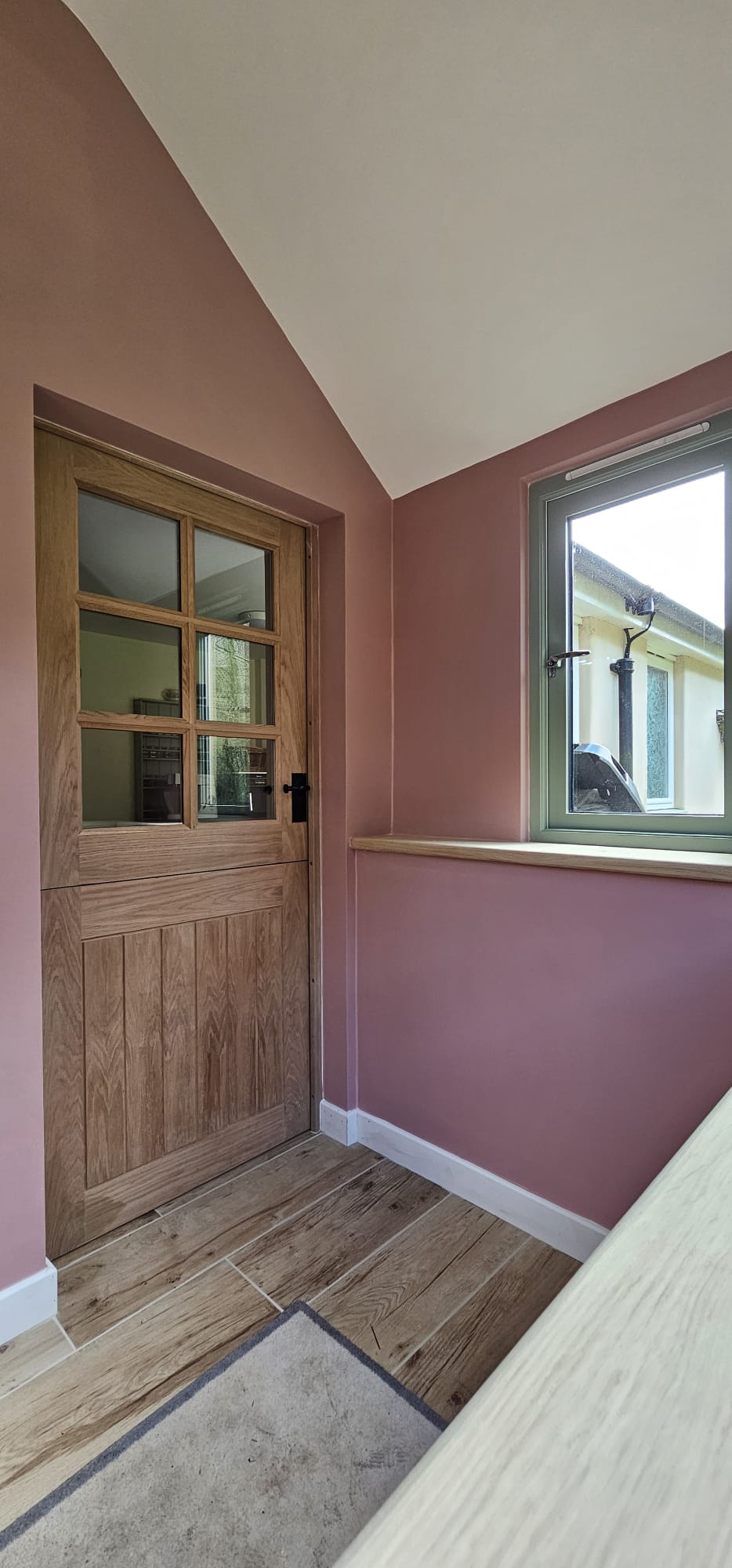 Inside the new porch, with a timber door, window and tiled floor